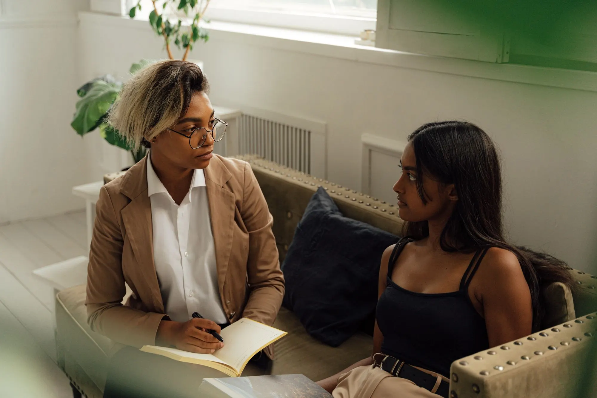 A counselor sitting with a client and offering calm, supportive attention